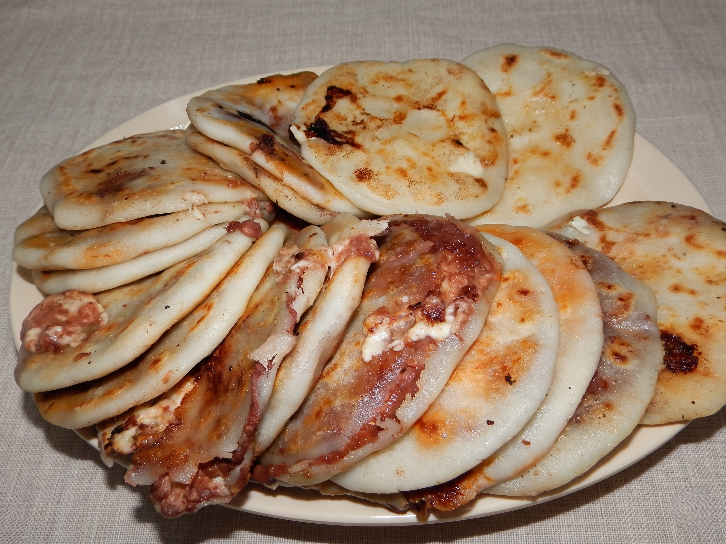 Pupusas servidas con curtido y salsa